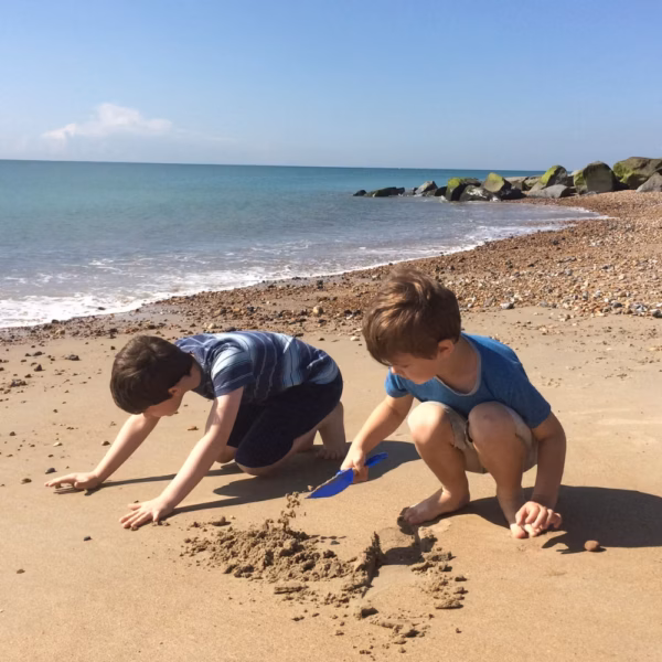 Two young people playing on the beach during the summer break