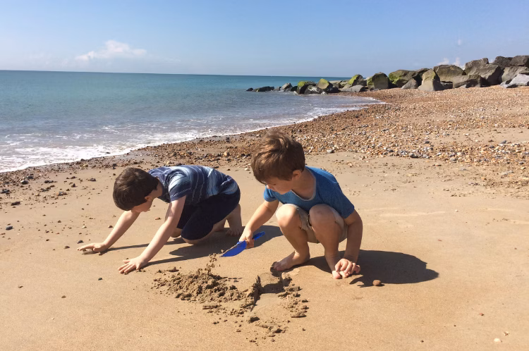 Two young people playing on the beach during the summer break